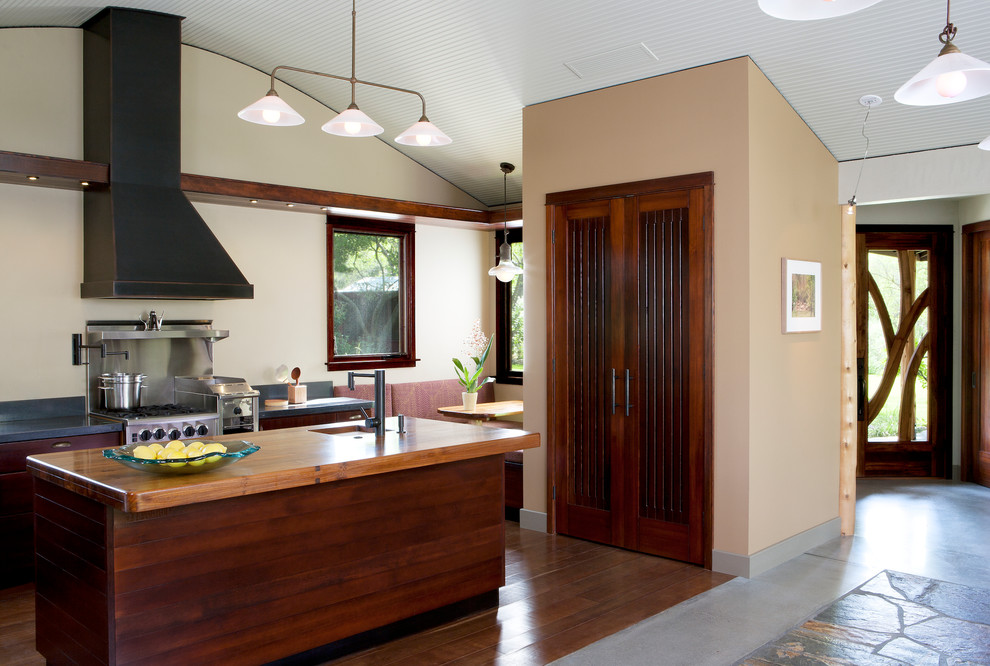 Стильный дизайн: кухня в современном стиле с деревянной столешницей, темными деревянными фасадами и техникой из нержавеющей стали - последний тренд
