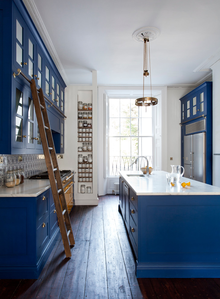 Klassische Küche mit Unterbauwaschbecken, Glasfronten, blauen Schränken, Küchengeräten aus Edelstahl, dunklem Holzboden und Kücheninsel in Dublin