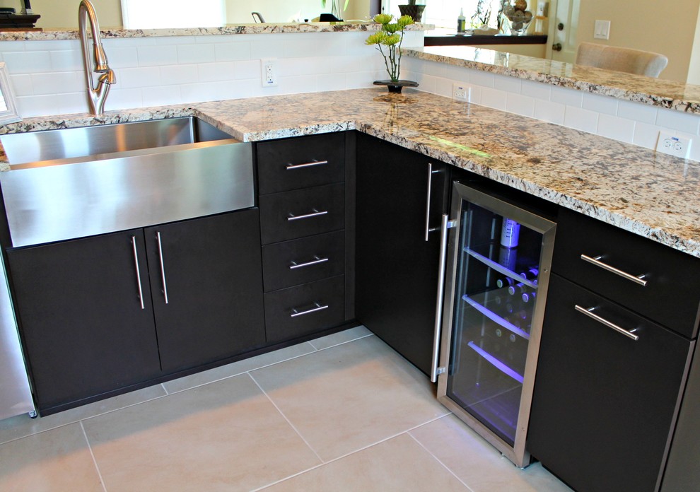 Example of a mid-sized minimalist u-shaped ceramic tile enclosed kitchen design in Milwaukee with a farmhouse sink, dark wood cabinets, granite countertops, white backsplash, subway tile backsplash, stainless steel appliances and a peninsula