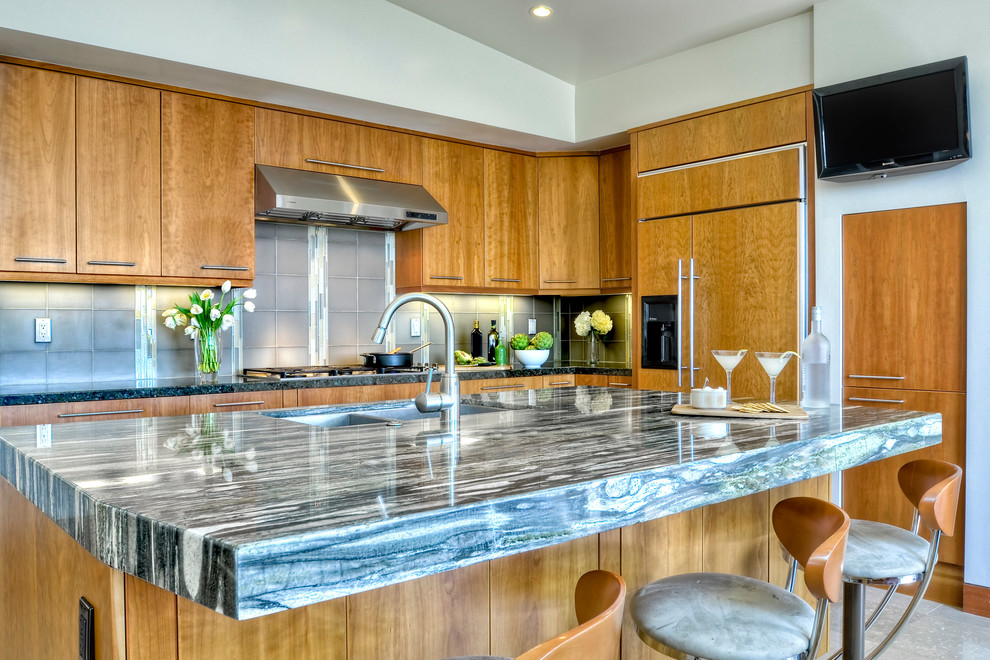 Large elegant l-shaped limestone floor eat-in kitchen photo in San Diego with a single-bowl sink, flat-panel cabinets, medium tone wood cabinets, granite countertops, multicolored backsplash, glass tile backsplash, stainless steel appliances and an island