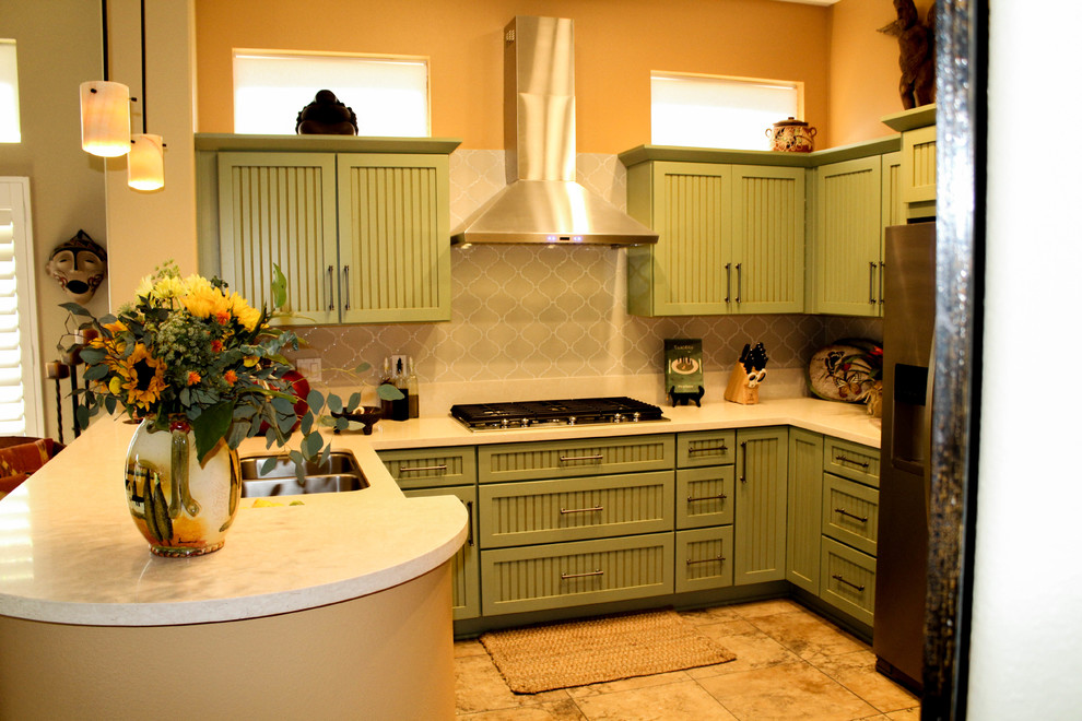 Klassisk inredning av ett mellanstort beige beige kök, med en undermonterad diskho, luckor med profilerade fronter, gröna skåp, bänkskiva i kvarts, beige stänkskydd, stänkskydd i keramik, rostfria vitvaror, klinkergolv i porslin, en halv köksö och beiget golv