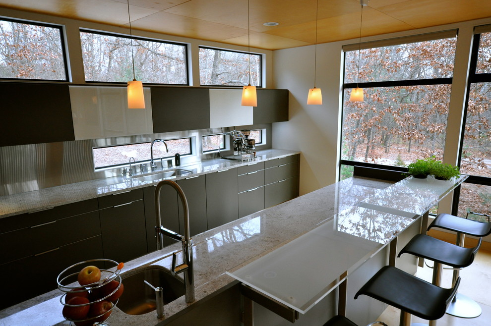 Стильный дизайн: параллельная кухня в современном стиле с обеденным столом, врезной мойкой, стеклянными фасадами, серыми фасадами, гранитной столешницей и техникой из нержавеющей стали - последний тренд