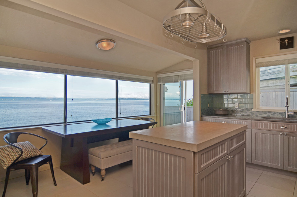 シアトルにある高級なビーチスタイルのおしゃれなキッチン (アンダーカウンターシンク、インセット扉のキャビネット、茶色いキャビネット、御影石カウンター、サブウェイタイルのキッチンパネル、シルバーの調理設備) の写真