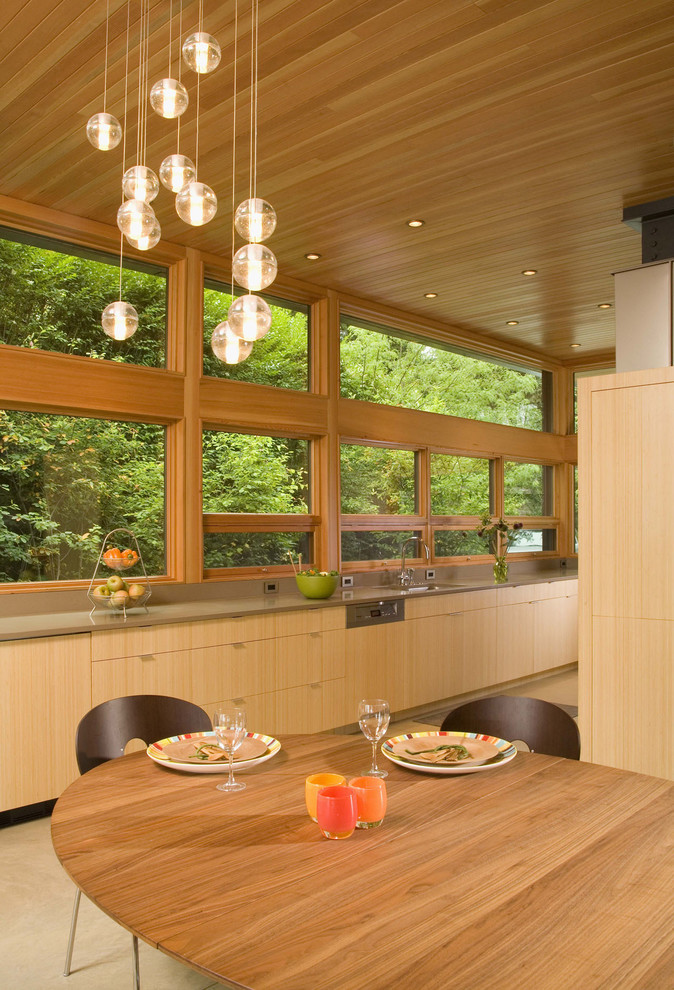 На фото: кухня в современном стиле с обеденным столом, плоскими фасадами и светлыми деревянными фасадами с