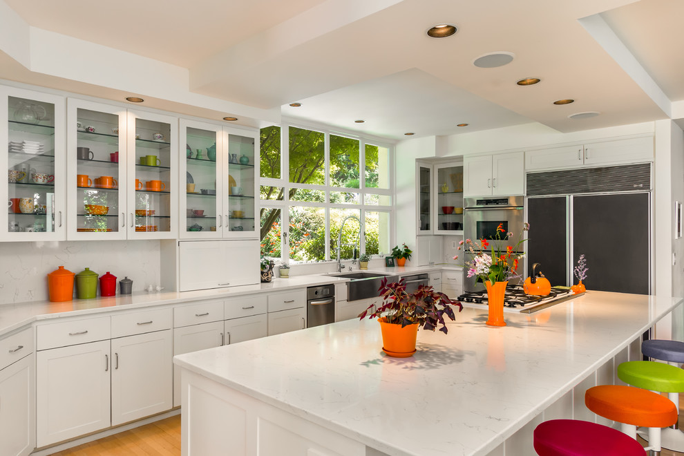 Klassische Küche mit Landhausspüle, Schrankfronten im Shaker-Stil, weißen Schränken, Küchenrückwand in Weiß, braunem Holzboden und Kücheninsel in Seattle