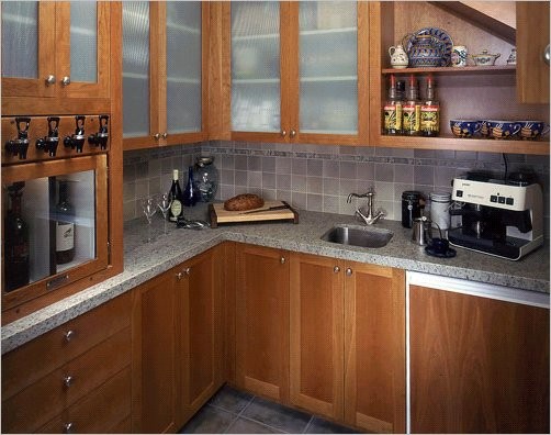 シアトルにある広いトラディショナルスタイルのおしゃれなキッチン (エプロンフロントシンク、落し込みパネル扉のキャビネット、中間色木目調キャビネット、グレーのキッチンパネル、シルバーの調理設備) の写真