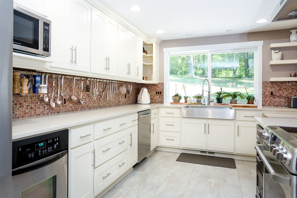 Photo of a medium sized traditional l-shaped enclosed kitchen in Portland with a belfast sink, shaker cabinets, white cabinets, stainless steel appliances, an island, engineered stone countertops, multi-coloured splashback, glass tiled splashback, ceramic flooring and white floors.
