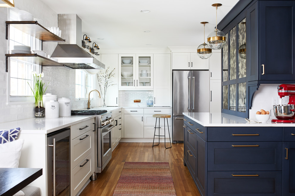 Idéer för ett mellanstort klassiskt vit kök, med en enkel diskho, skåp i shakerstil, blå skåp, bänkskiva i kvarts, vitt stänkskydd, stänkskydd i tunnelbanekakel, rostfria vitvaror, mellanmörkt trägolv, en halv köksö och brunt golv