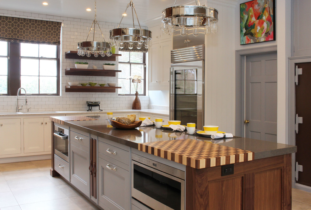 ニューヨークにあるトランジショナルスタイルのおしゃれなアイランドキッチン (白いキャビネット、グレーのキッチンパネル、シルバーの調理設備、クオーツストーンカウンター) の写真