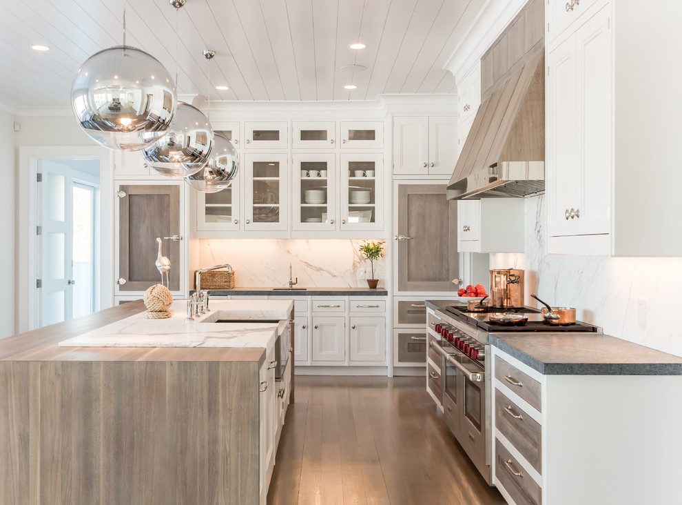 Inspiration for a large coastal l-shaped light wood floor kitchen remodel in Other with a farmhouse sink, white backsplash, stainless steel appliances and an island