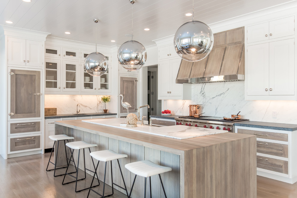 Inspiration for a large nautical kitchen in Other with white splashback, stainless steel appliances, light hardwood flooring, an island, white cabinets and recessed-panel cabinets.