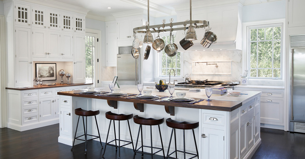 Inspiration for a classic l-shaped kitchen in New York with recessed-panel cabinets, white cabinets, white splashback, stainless steel appliances, dark hardwood flooring and an island.