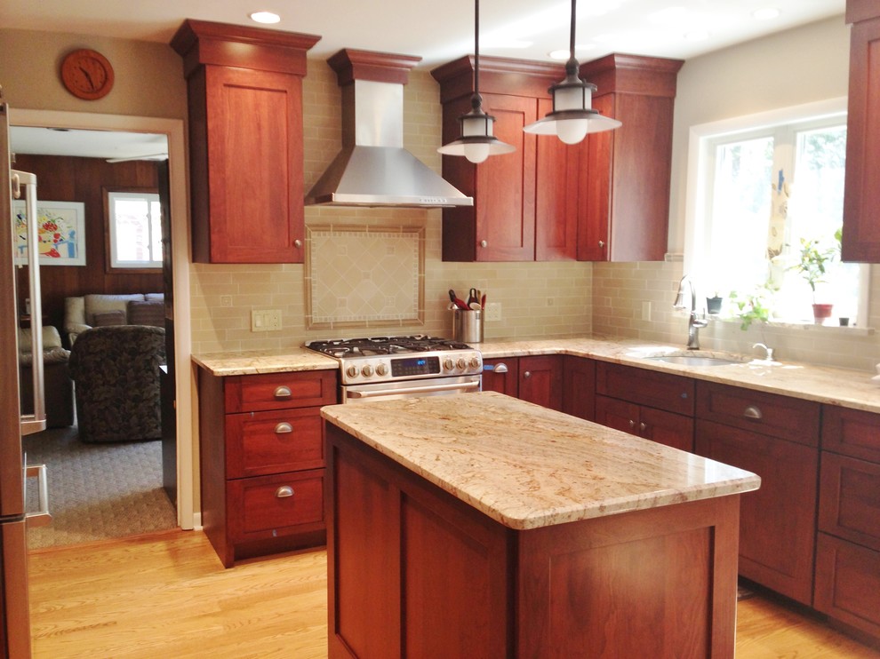 Mid-sized arts and crafts l-shaped light wood floor enclosed kitchen photo in Philadelphia with an undermount sink, shaker cabinets, dark wood cabinets, granite countertops, beige backsplash, stone tile backsplash, stainless steel appliances and an island