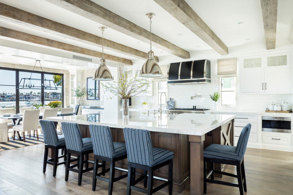 Свежая идея для дизайна: прямая кухня в морском стиле с обеденным столом, белыми фасадами и островом - отличное фото интерьера
