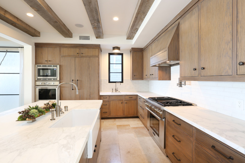 Inspiration for a coastal light wood floor kitchen remodel in Orange County with distressed cabinets, marble countertops, paneled appliances, an island and white backsplash