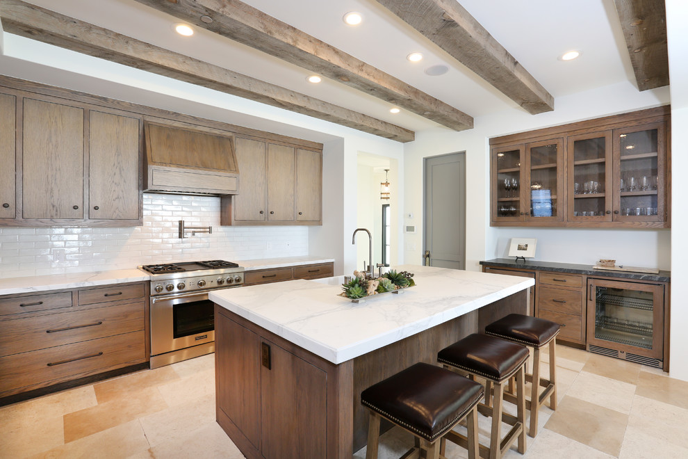 Example of a beach style light wood floor kitchen design in Orange County with medium tone wood cabinets, white backsplash, an island and paneled appliances
