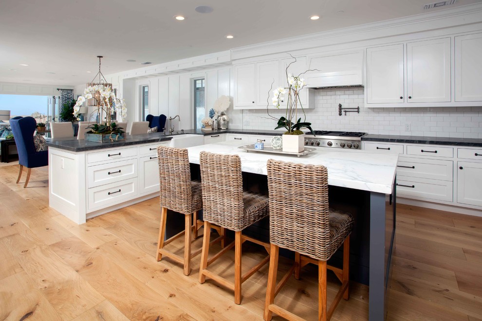 Design ideas for a coastal kitchen in Orange County with light hardwood flooring.