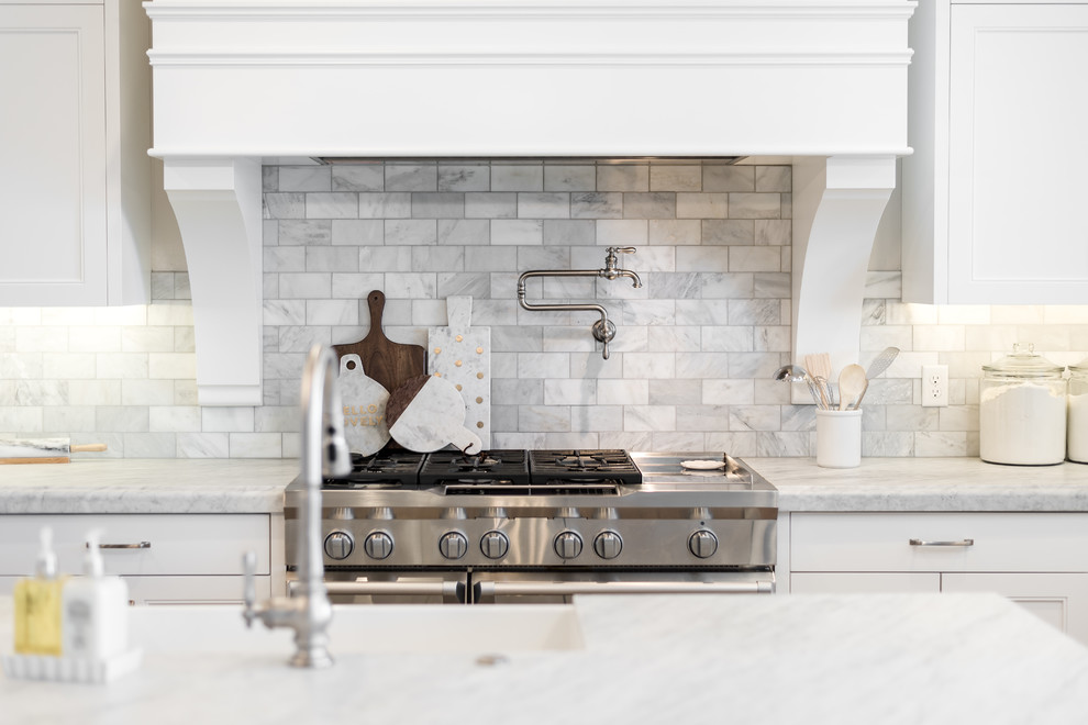 Bild på ett mellanstort vintage vit vitt u-kök, med en rustik diskho, skåp i shakerstil, vita skåp, marmorbänkskiva, grått stänkskydd, stänkskydd i marmor, integrerade vitvaror, mellanmörkt trägolv, en köksö och flerfärgat golv