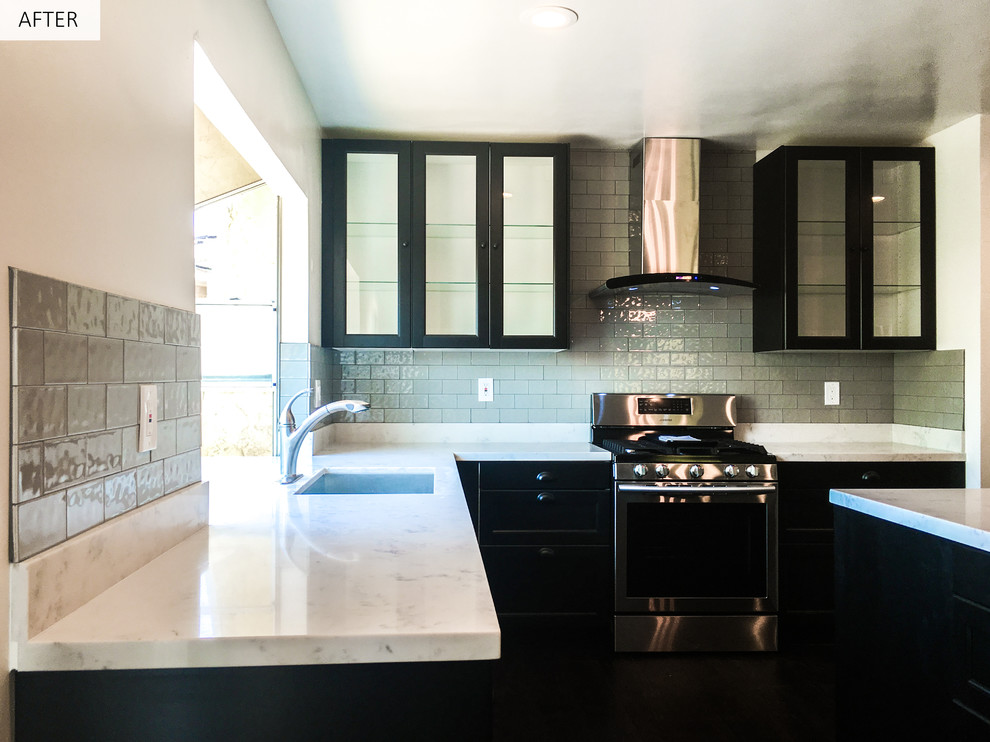 Bild på ett mellanstort funkis kök, med en undermonterad diskho, svarta skåp, bänkskiva i kvarts, grått stänkskydd, stänkskydd i tunnelbanekakel, rostfria vitvaror, mörkt trägolv, en köksö och luckor med glaspanel