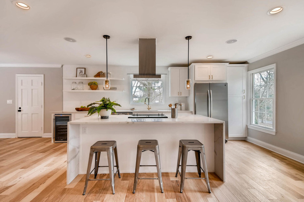 Inspiration for a contemporary galley medium tone wood floor and brown floor kitchen remodel in Baltimore with shaker cabinets, white cabinets, white backsplash, stainless steel appliances, an island and white countertops