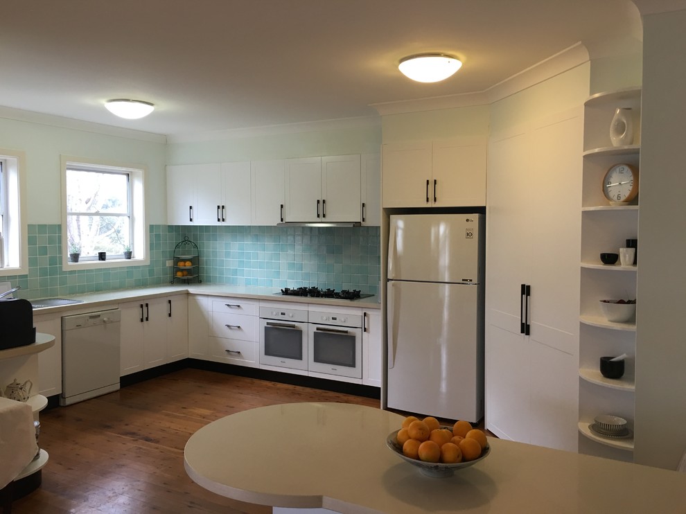 На фото: большая п-образная кухня в стиле модернизм с кладовкой, фасадами в стиле шейкер, белыми фасадами, синим фартуком и фартуком из керамической плитки