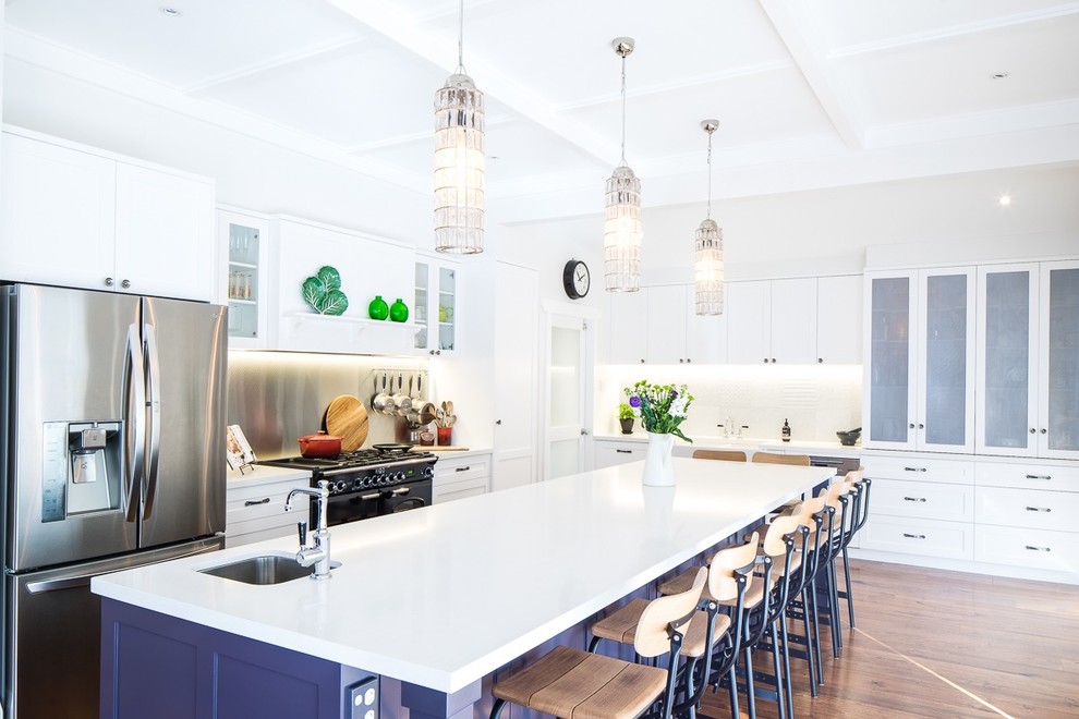 Klassische Küche in L-Form mit Schrankfronten im Shaker-Stil, weißen Schränken, Küchenrückwand in Weiß, Küchengeräten aus Edelstahl, dunklem Holzboden und Kücheninsel in Sydney