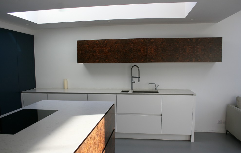 Inspiration for a mid-sized contemporary concrete floor eat-in kitchen remodel in London with an undermount sink, flat-panel cabinets, dark wood cabinets, quartz countertops, stainless steel appliances and an island