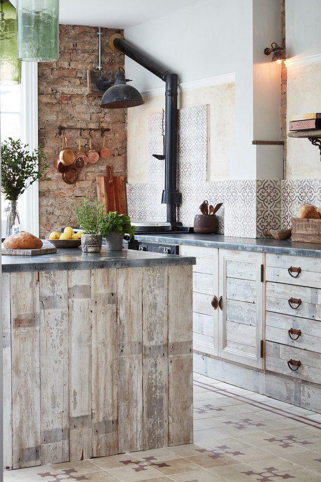 Inspiration for a rustic open plan kitchen in London with distressed cabinets, multi-coloured splashback, ceramic splashback, black appliances, ceramic flooring, an island and multi-coloured floors.