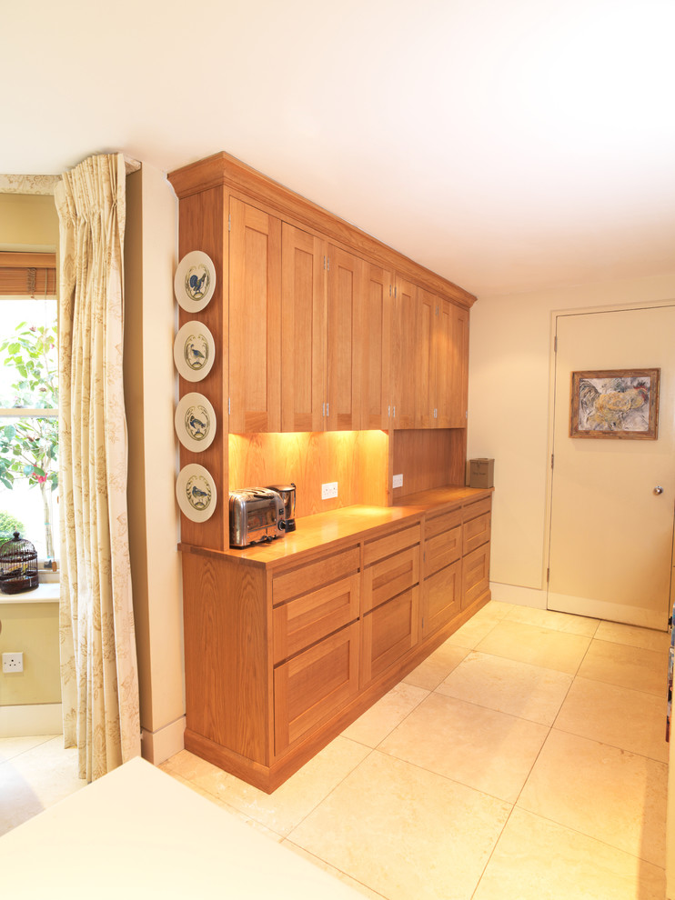 This is an example of a medium sized contemporary galley open plan kitchen in Other with recessed-panel cabinets, medium wood cabinets, wood worktops, limestone flooring and an island.