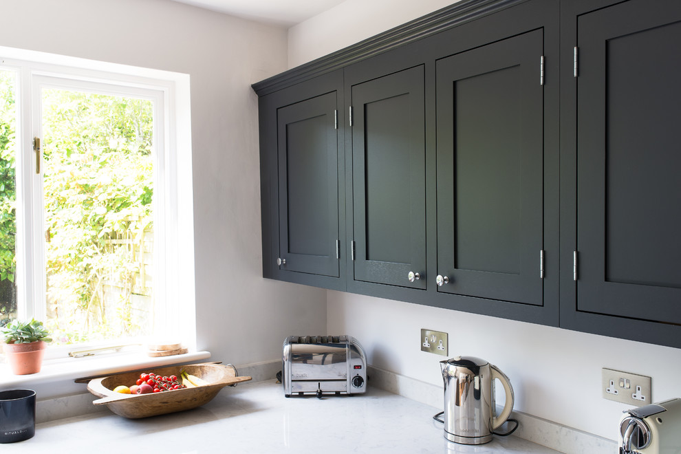 Imagen de cocina comedor de estilo de casa de campo pequeña con armarios estilo shaker, puertas de armario de madera en tonos medios y suelo de madera clara