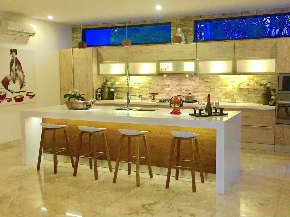 Inspiration for a large zen single-wall marble floor eat-in kitchen remodel with an undermount sink, flat-panel cabinets, light wood cabinets, solid surface countertops, multicolored backsplash, stone tile backsplash, stainless steel appliances and an island