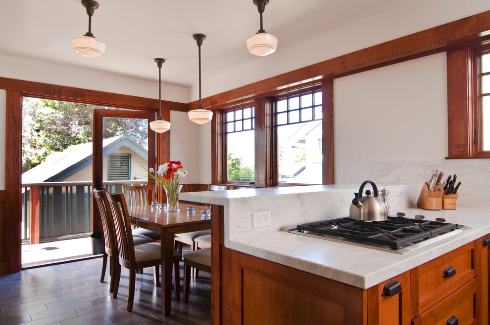 На фото: кухня в стиле кантри с обеденным столом, фасадами с утопленной филенкой и фасадами цвета дерева среднего тона с