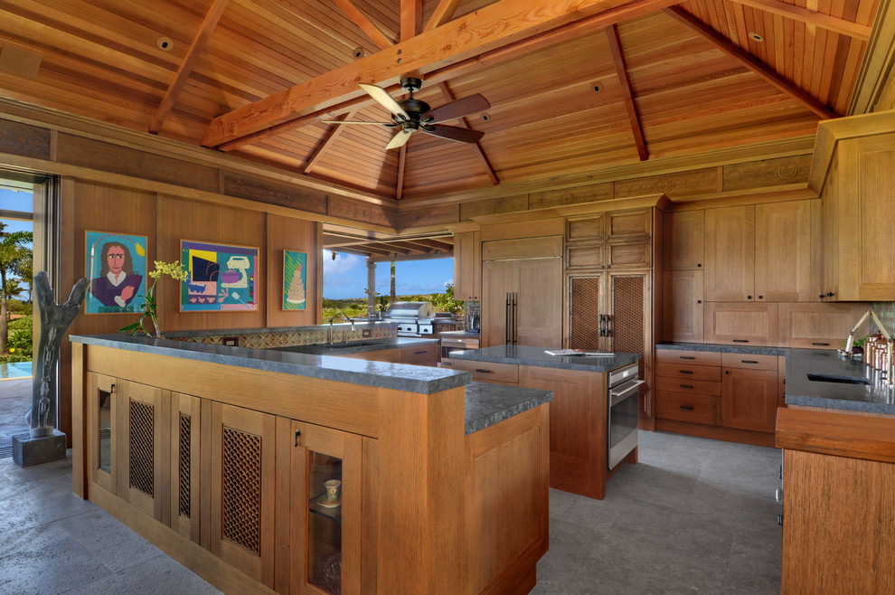 This is an example of a world-inspired u-shaped kitchen in Hawaii with medium wood cabinets and integrated appliances.