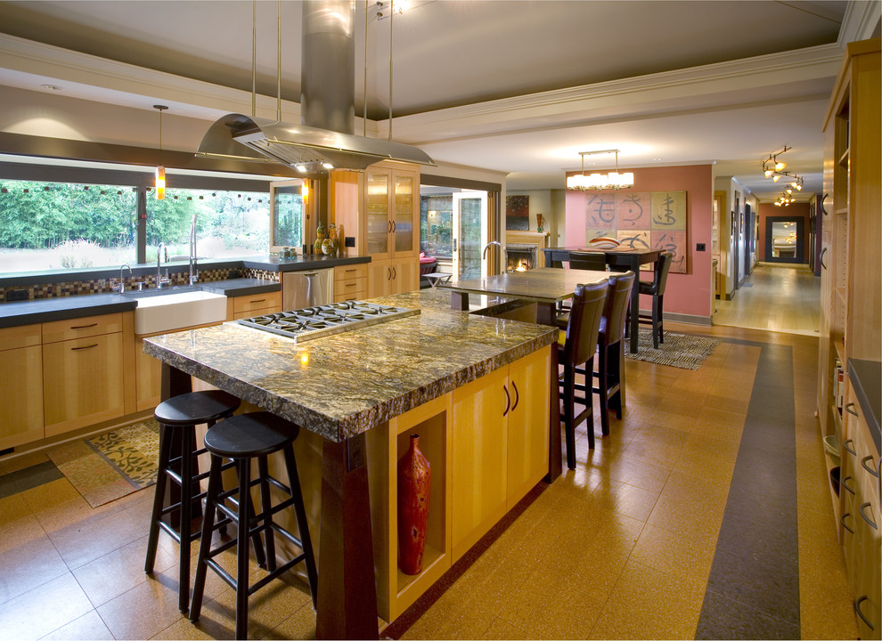 На фото: кухня в восточном стиле с обеденным столом, с полувстраиваемой мойкой (с передним бортиком), гранитной столешницей, плоскими фасадами, светлыми деревянными фасадами, разноцветным фартуком, фартуком из плитки мозаики и барной стойкой с