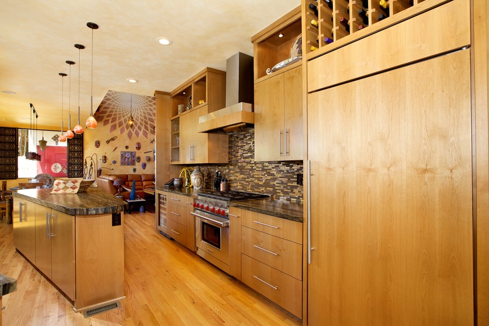 Exempel på ett exotiskt kök, med släta luckor, skåp i ljust trä, granitbänkskiva, flerfärgad stänkskydd, stänkskydd i mosaik, rostfria vitvaror, ljust trägolv och en köksö