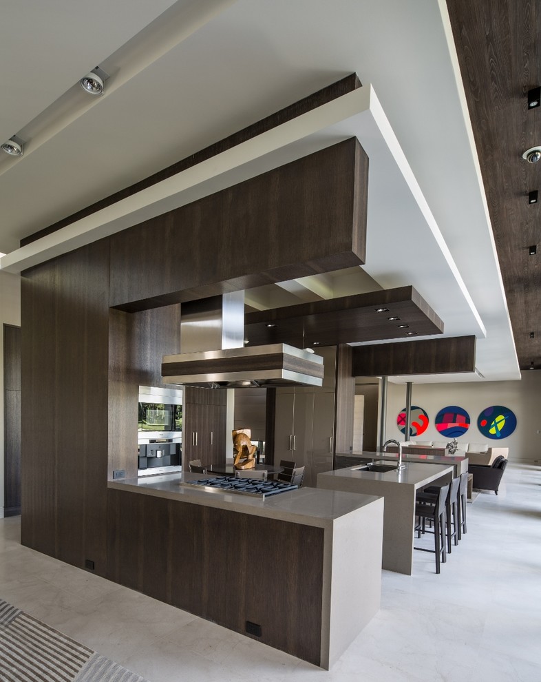 Photo of a large contemporary open plan kitchen in Miami with limestone flooring, a submerged sink, flat-panel cabinets, dark wood cabinets and multiple islands.