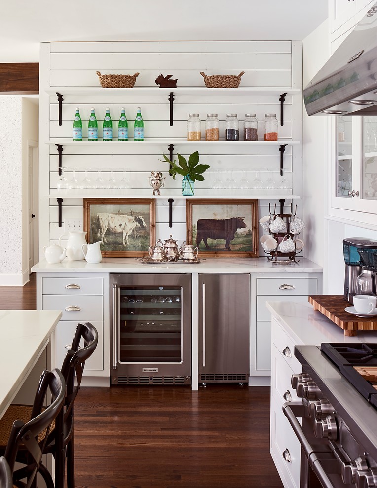 Inspiration for a farmhouse l-shaped dark wood floor and brown floor kitchen remodel in Charlotte with flat-panel cabinets, white cabinets, white backsplash, subway tile backsplash and stainless steel appliances