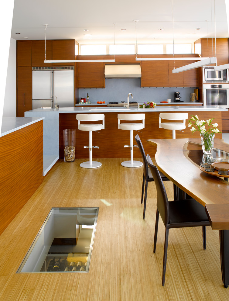 Esempio di una cucina minimalista di medie dimensioni con ante lisce, ante in legno scuro, paraspruzzi grigio, elettrodomestici in acciaio inossidabile, lavello a doppia vasca e parquet chiaro