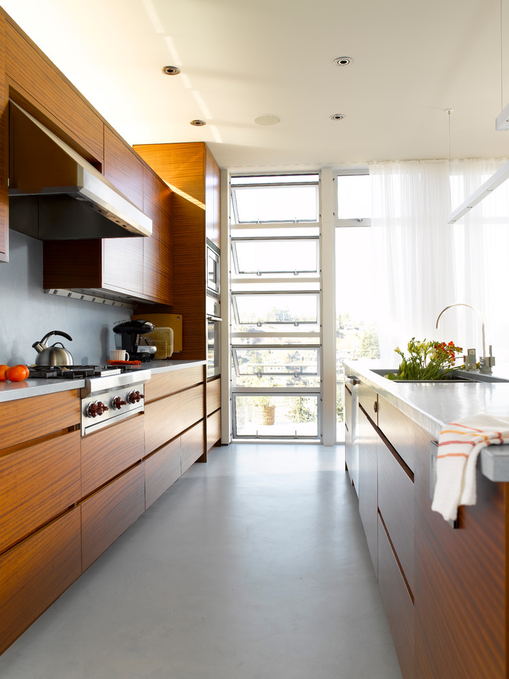 Foto de cocina moderna de tamaño medio con fregadero de doble seno, armarios con paneles lisos, puertas de armario de madera oscura, salpicadero verde y electrodomésticos de acero inoxidable