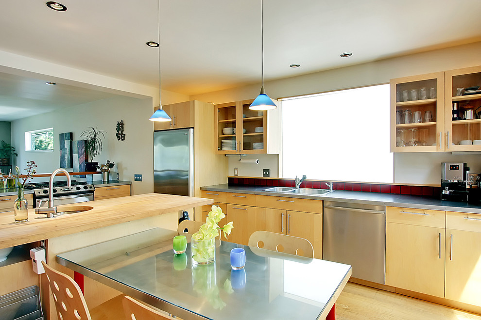 Moderne Wohnküche mit Küchengeräten aus Edelstahl, Doppelwaschbecken, flächenbündigen Schrankfronten, hellen Holzschränken, Arbeitsplatte aus Holz und Küchenrückwand in Rot in Seattle