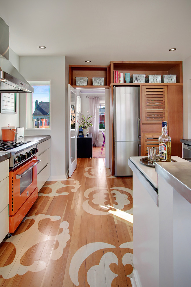 Foto di una cucina minimal chiusa con top in zinco e elettrodomestici colorati