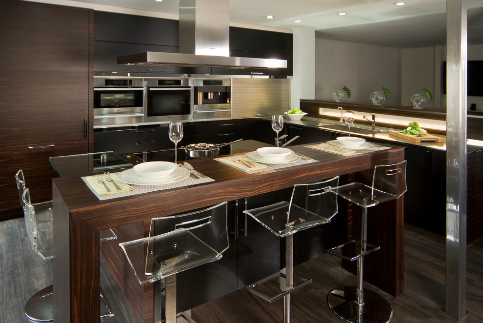 Exempel på ett mellanstort modernt kök, med släta luckor, träbänkskiva, en undermonterad diskho, skåp i mörkt trä, rostfria vitvaror, mörkt trägolv och en köksö