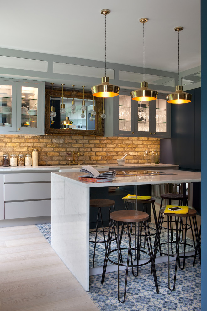Стильный дизайн: прямая кухня в стиле лофт с обеденным столом, стеклянными фасадами, серыми фасадами, бежевым фартуком, фартуком из кирпича и островом - последний тренд