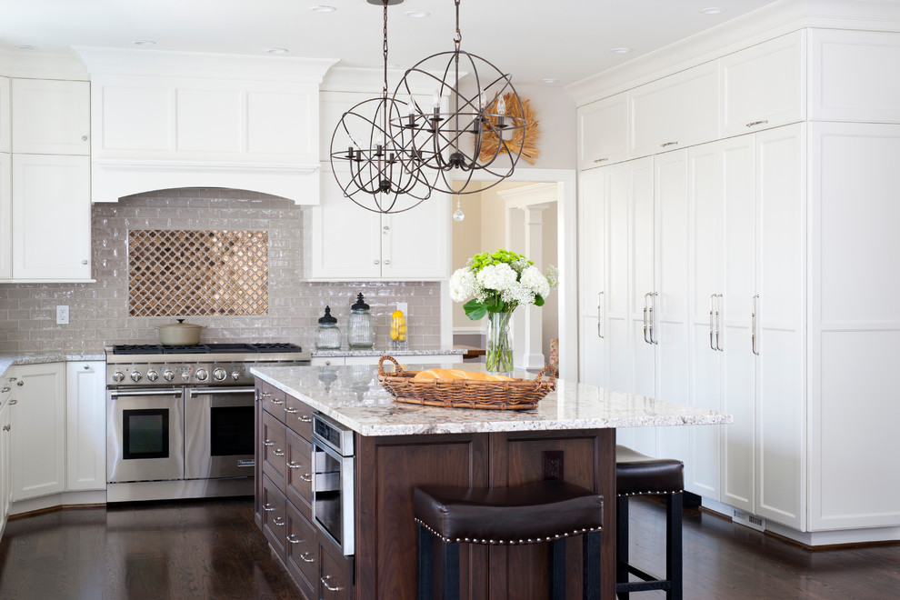 Example of a large transitional u-shaped dark wood floor eat-in kitchen design in DC Metro with an undermount sink, shaker cabinets, white cabinets, granite countertops, beige backsplash, ceramic backsplash, stainless steel appliances and an island
