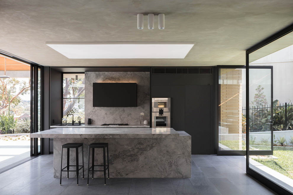 Große, Zweizeilige Moderne Küche mit flächenbündigen Schrankfronten, schwarzen Schränken, Küchengeräten aus Edelstahl, Kücheninsel, grauem Boden, grauer Arbeitsplatte und Marmor-Arbeitsplatte in Sydney