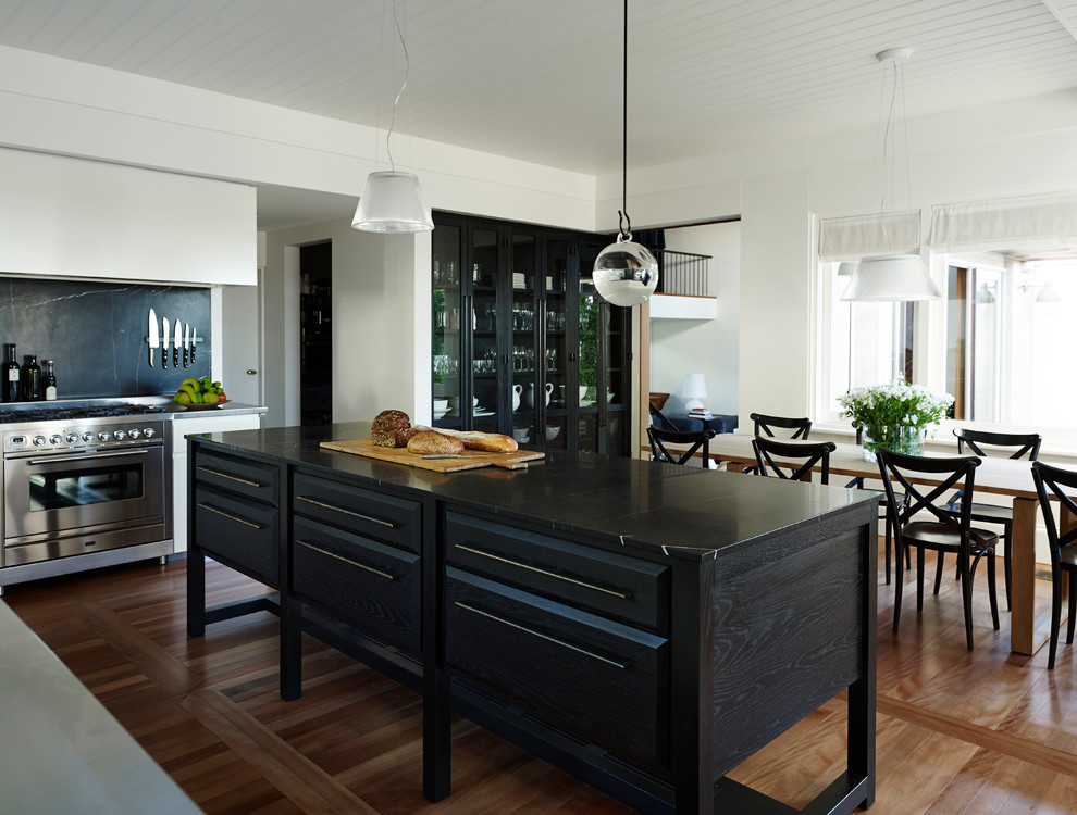Moderne Küche mit flächenbündigen Schrankfronten, weißen Schränken, Küchengeräten aus Edelstahl, braunem Holzboden und Kücheninsel in Sydney