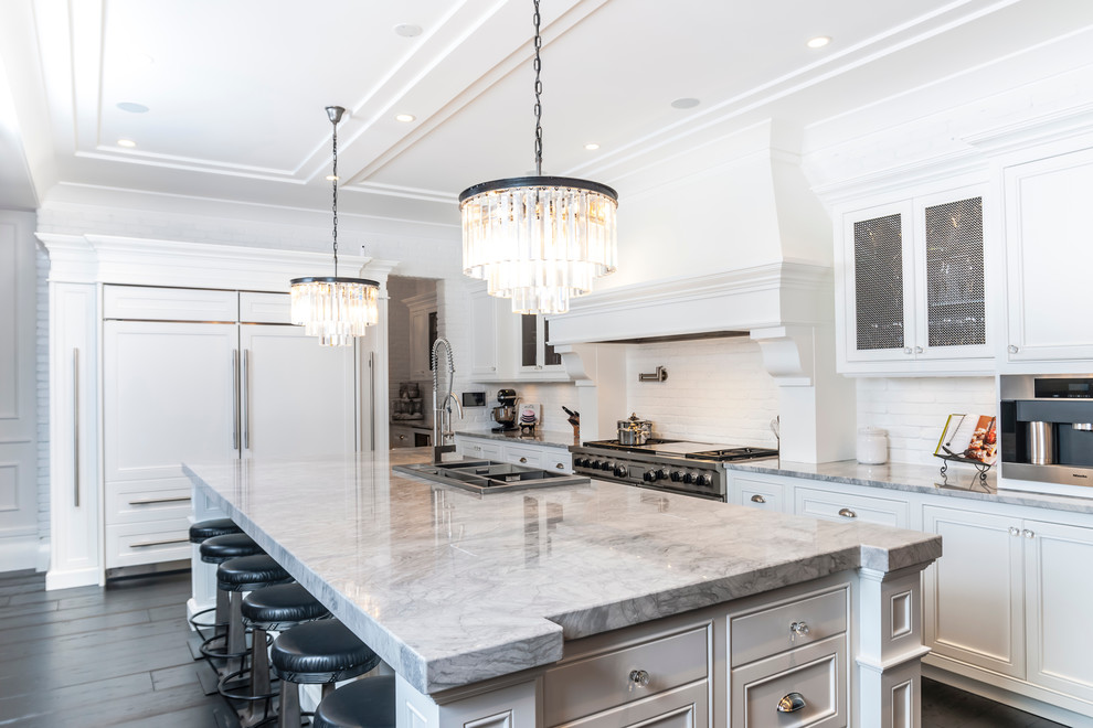 Photo of a classic kitchen in Edmonton with recessed-panel cabinets, white cabinets, white splashback and integrated appliances.