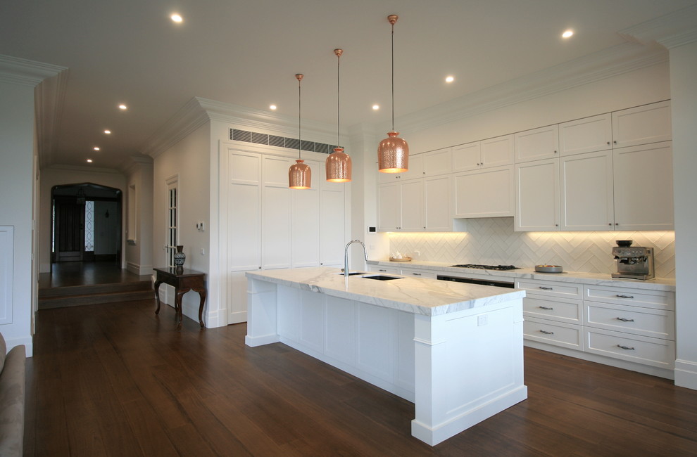 Design ideas for a large classic l-shaped open plan kitchen in Melbourne with shaker cabinets, white cabinets, marble worktops, white splashback, porcelain splashback, dark hardwood flooring, an island and white worktops.