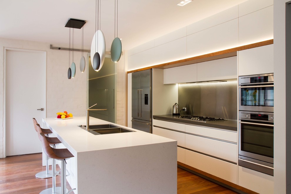 Large contemporary galley kitchen/diner in Melbourne with flat-panel cabinets, white cabinets, engineered stone countertops and an island.