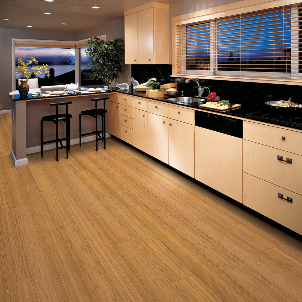 Eat-in kitchen - large transitional l-shaped bamboo floor eat-in kitchen idea in New York with a single-bowl sink, flat-panel cabinets, light wood cabinets, black backsplash, paneled appliances and a peninsula
